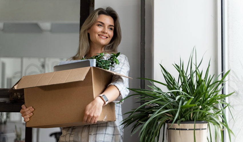 Woman carrying a moving box while moving to a new home